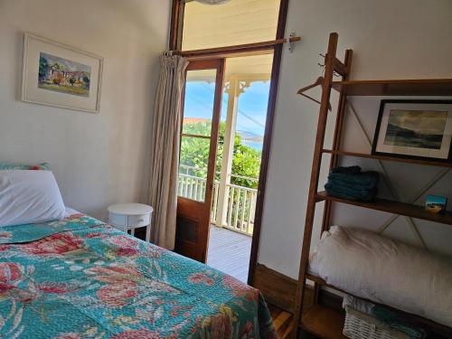Schlafzimmer mit einem Bett und Blick auf einen Balkon in der Unterkunft Brony's Beachfront-Short and Long Term Stays in Porirua