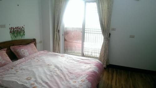 a bedroom with a bed and a large window at Cuiti B&B in Fenchihu