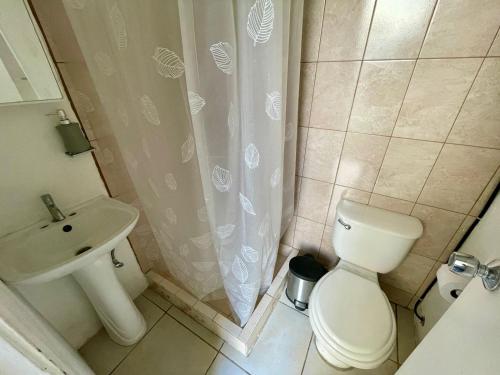 a bathroom with a toilet and a shower curtain at Casa Quetzal in Guatemala