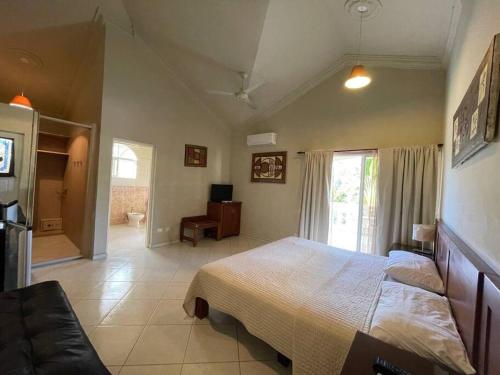 ein Schlafzimmer mit einem Bett und einem TV in der Unterkunft Luxury Villa Classic style - 7 min. from the beach in San Felipe de Puerto Plata