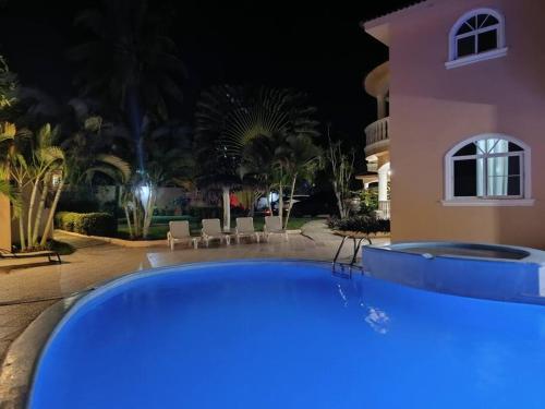 ein großer blauer Pool vor einem Haus in der Nacht in der Unterkunft Luxury Villa Classic style - 7 min. from the beach in San Felipe de Puerto Plata