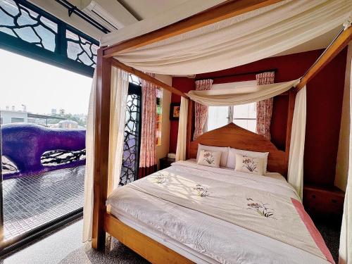 小琉球的住宿－小琉球鄉村民宿，一间卧室配有一张天蓬床和窗户
