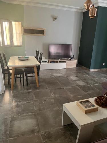 a living room with a table and a television at joli appart 2 chambres salon liberté 6 extension in Dakar