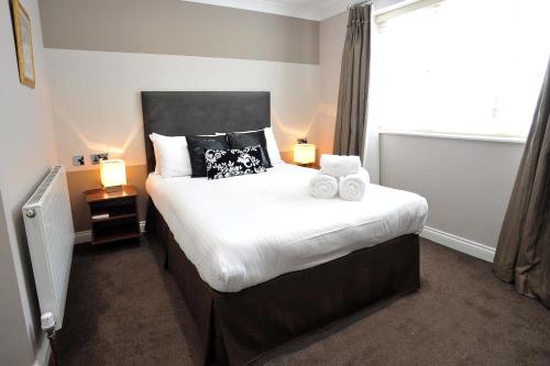 a bedroom with a bed with two towels on it at The Kings Arms Hotel in Berwick-Upon-Tweed