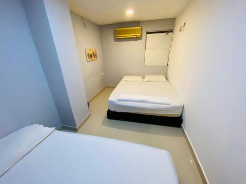 um pequeno quarto com uma pequena cama em RAS Hotel em Kuala Lumpur