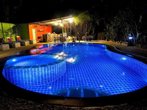 a large pool with blue tiles on it at night at Kamrai Homestay in Ko Chang