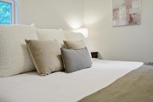 Una cama blanca con dos almohadas encima. en Downtown Hillsborough Duplex, en Hillsborough