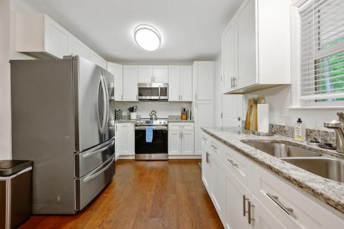 a kitchen with white cabinets and a stainless steel refrigerator at Downtown Hillsborough Duplex in Hillsborough