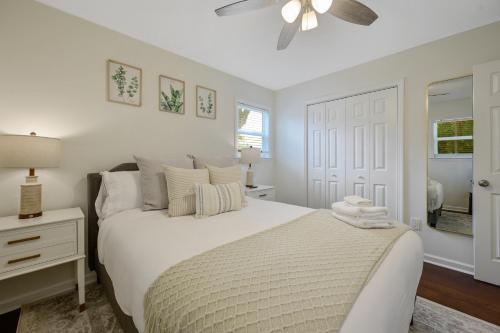 a white bedroom with a bed and a ceiling fan at Downtown Hillsborough Duplex in Hillsborough