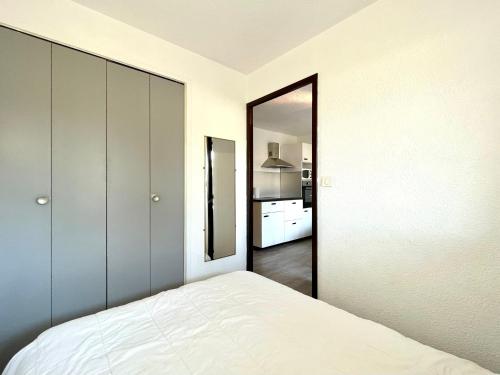 une chambre avec un lit et un grand miroir dans l'établissement Sète: 2 pièces à 200m plage, parking & loggia - FR-1-338-11, à Sète