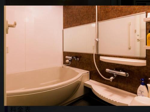 a bathroom with a tub and a toilet and a sink at ホテルR -Adult only- in Gotemba