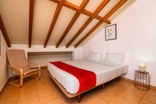 a bedroom with a bed and a chair in a room at Apartment 1BR Hills over Ponta do Sol, sea view in Ponta do Sol