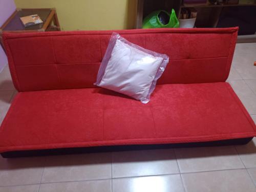 un sofá rojo con una almohada encima en CASA JEI, en Iquitos