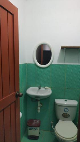 een badkamer met een toilet, een wastafel en een spiegel bij CASA JEI in Iquitos