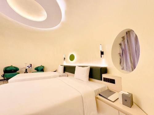 a white room with two beds and a table at Mộc Châu Island - Lune Village in Mộc Châu