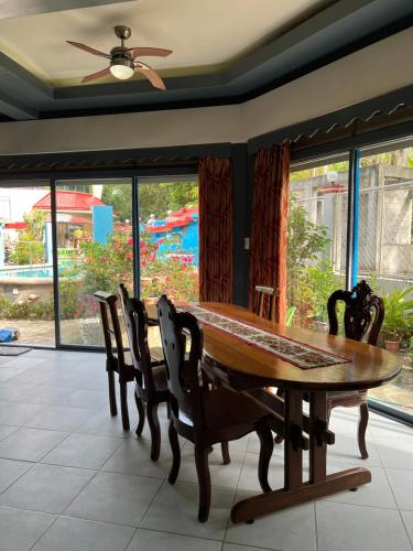 a dining room with a wooden table and chairs at Heaven’s Gate Resort in Puerto Galera