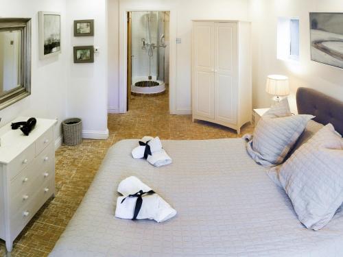 1 dormitorio con 1 cama con toallas en The Old Pool House, en Charlton Abbots