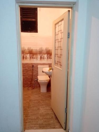 uma casa de banho com um WC e uma janela em KGIS em Gelioya