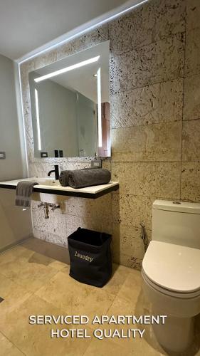 a bathroom with a sink and a toilet and a mirror at Serviced Apartment Pretty Penthouse Valencia in Valencia