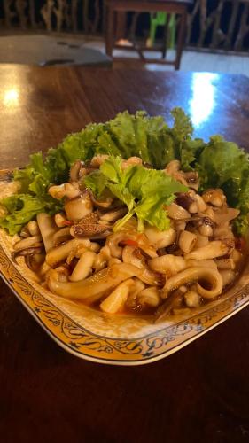 a plate of food with pasta and lettuce on a table at Koh Rong 71 Guesthouse in Koh Rong Island