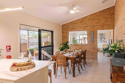 a kitchen and dining room with a table and chairs at Budgaribah in Old Bar