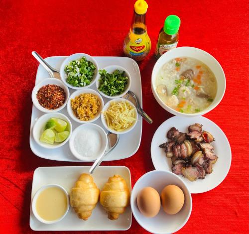 einen Tisch mit Teller mit Lebensmitteln auf einem roten Tisch in der Unterkunft Lungwang Guest House in Ban Rak Thai