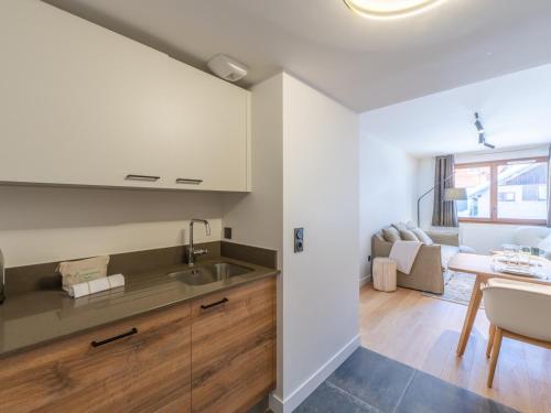 a kitchen and living room with a sink and a table at Charmant appt de 41m² au cœur du Vieil Alpe, proche pistes, idéal pour 4 pers, tout confort, WiFi inclus - FR-1-645-67 in LʼHuez