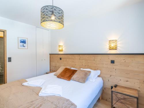 a bedroom with a white bed and a chandelier at Charmant appt de 41m² au cœur du Vieil Alpe, proche pistes, idéal pour 4 pers, tout confort, WiFi inclus - FR-1-645-67 in LʼHuez