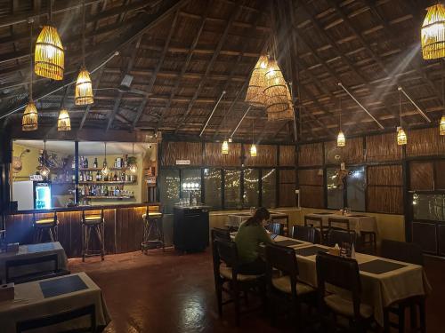 un hombre sentado en una mesa en un restaurante en Hotel Tharu Garden, Sauraha, en Sauraha