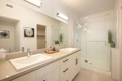 ein weißes Bad mit 2 Waschbecken und einer Dusche in der Unterkunft Luxury NEW Residence with Private Rooftop, Downtown in minutes in San Diego