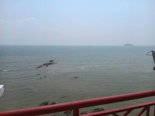 a view of the ocean from a red fence at Paradise Lagoon Apartment South in Port Dickson