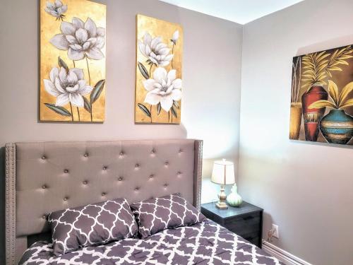 a bedroom with a bed with two paintings on the wall at Brand new house in downtown with parking in Buffalo