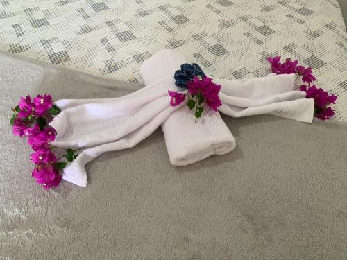- une paire de serviettes avec des fleurs sur le lit dans l'établissement I Chalés O Sertanejo BG, à Barra Grande