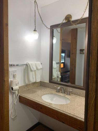 y baño con lavabo y espejo. en Bridge Inn Tomahawk -1st Floor, 2 Queen Size Bed, Walkout, River View, en Tomahawk