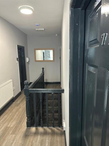 a hallway with a staircase with a green wall and a door at Castle Lodge in Nottingham