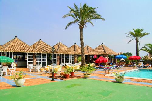 a patio area with a pool, chairs, tables and umbrellas at Ona Marina Arpón in La Manga del Mar Menor