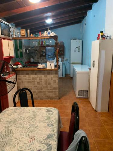 cocina con mesa y nevera en la casa de la pitufa en Villa Rosa