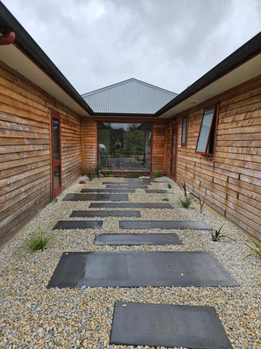 a walkway in front of a building at Tamata Estate House Farm stay in Marokopa