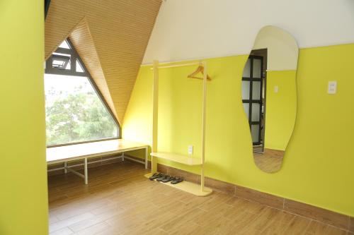 Zimmer mit einem Spiegel, einem Schreibtisch und einem Fenster in der Unterkunft AN PHÚ Home in Da Lat
