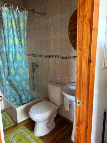 a bathroom with a toilet and a sink at Cabañas La Tranquilidad in Purranque