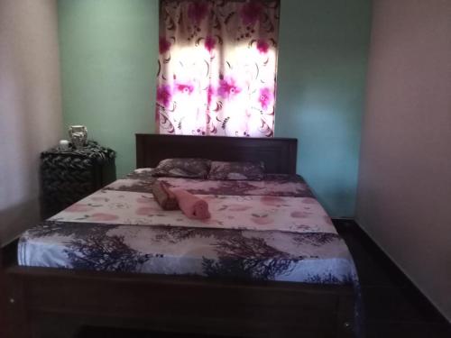 um quarto com uma cama com uma cortina florida em Sky Galaxy Homestay em Dickwella