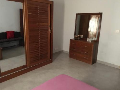 een woonkamer met een spiegel en een dressoir bij joli appart F2 de 80m2 à liberté 6 extension in Dakar