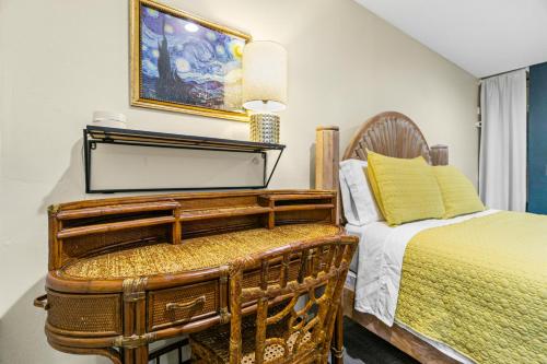 a bedroom with a bed and a table and a chair at Mile to Beach! Tiki Master Suite in Oceanside