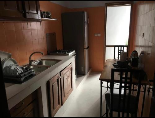 a kitchen with a sink and a refrigerator and a table at joli appart F2 de 80m2 à liberté 6 extension in Dakar
