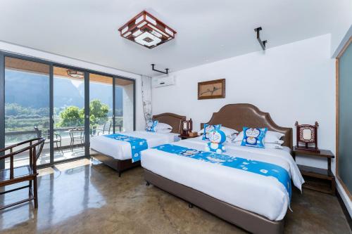 a bedroom with two beds and a balcony at Leisure Courtyard Hotel Yangshuo in Yangshuo