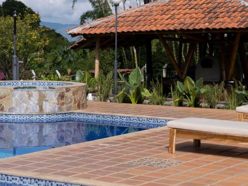 a swimming pool with a bench next to a house at Finca Hotel Santana in Montenegro