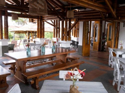 comedor con mesa de madera y sillas en Finca Hotel Santana en Montenegro