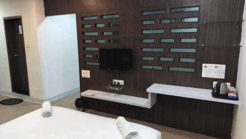a room with a tv on a wooden wall at HOTEL SWAASTIK in Pune