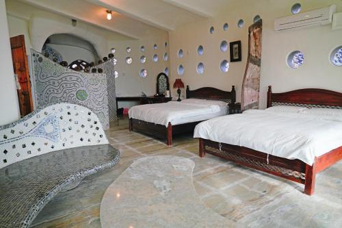 a room with two beds and two chairs at 鳳凰城堡2F in Chia-p'ing