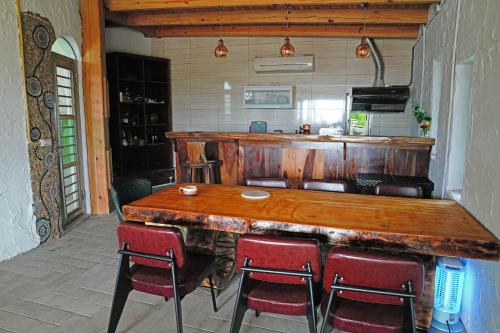 a large wooden bar in a kitchen with red chairs at 鳳凰城堡2F in Chia-p'ing